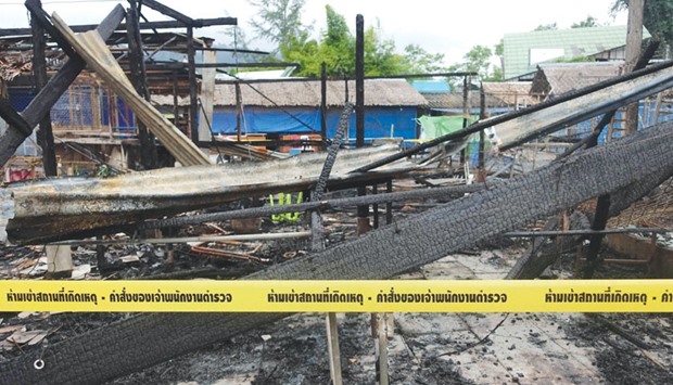 Police tape is seen cordoning off the remains of buildings at the site of the small bomb blast and arson attack on Bang Niang market, Takua Pa, in Phang Nga province.