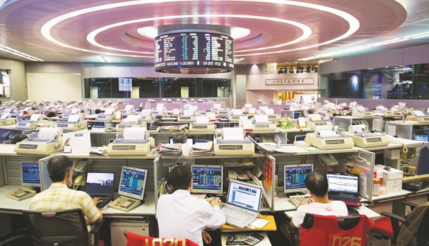 Traders work at the Hong Kong Stock Exchange. The Hang Seng closed up 1.1% to 22,129.14 points yesterday.