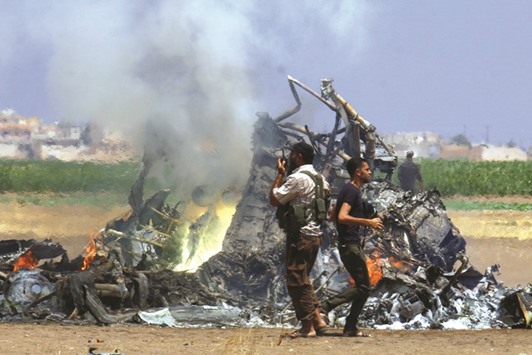 Men inspect the wreckage of a Russian helicopter that had been shot down in the north of Syriau2019s rebel-held Idlib province, Syria, yesterday.