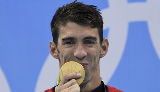 Michael Phelps poses with his gold medal on the podium after winning the men\'s 200m individual medley final at the Rio 2016 Olympic Games at the Olympic Aquatics Stadium.
