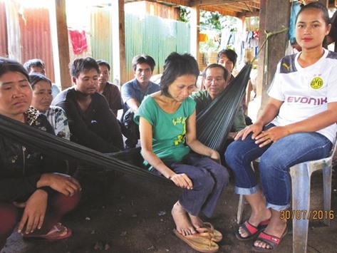 A handout photo released by the Cambodian Human Rights and Development Association (ADHOC) showing u201cjungle girlu201d Rochom Pu2019ngieng (centre) sitting on a hammock as a Vietnamese man who claims to be her real father sits behind her at a village in  Rattanak Kiri province.