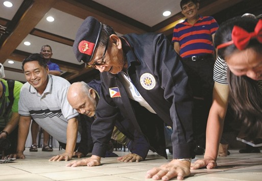 Former Philippine president Fidel Ramos (centre) does 10 push-ups after a press conference at Camp Aguinaldo in Manila yesterday.