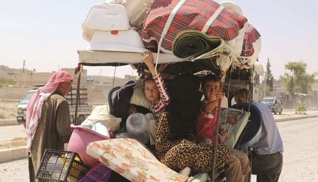 Syrian children sit in a cart, loaded with belongings, in the northern Syrian town of Manbij as civilians go back to their homes yesterday more than a week after the Arab-Kurdish alliance, known as the Syrian Democratic Forces (SDF), pushed the Islamic State (IS) group out of the city.