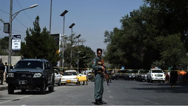 An Afghan security official stands alert at the site of a suicide bomb attack near the US embassy in Kabul on Monday. At least three people were injured in a sticky bomb blast targeting a vehicle of a member of the defence ministry staff.