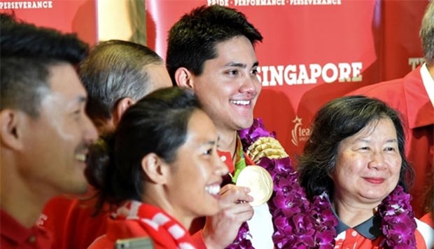Singaporean swimmer Joseph Schooling and his mother May (right) pose for a group photo upon arrival from the Rio 2016 Olympic Games at Changi International Airport on Monday.