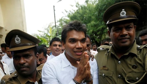 Namal Rajapaksa, son of former Sri Lanka's president Mahinda Rajapaksa, leaves with prison officers after being arrested in Colombo last month.