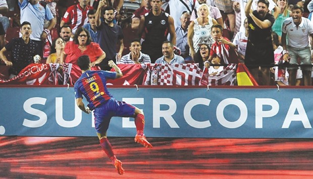 Barcelonau2019s Uruguayan forward Luis alberto Suarez celebrates after scoring during the first leg of the Spanish Supercup football match between Sevilla FC and FC Barcelona.