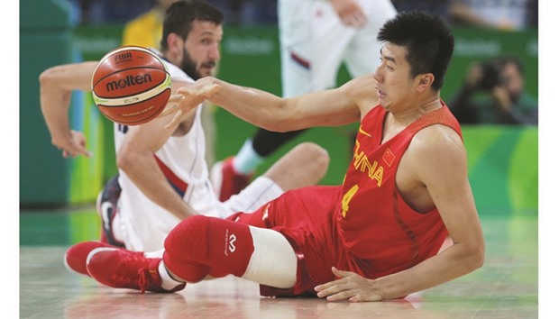 Zou Yuchen of China tries to grab a loose ball from Stefan Bircevic of Serbia during their Group A match on Sunday. Serbia thumped winless China 94-60 to finish fourth and grab a spot in the knockout round. (Reuters)