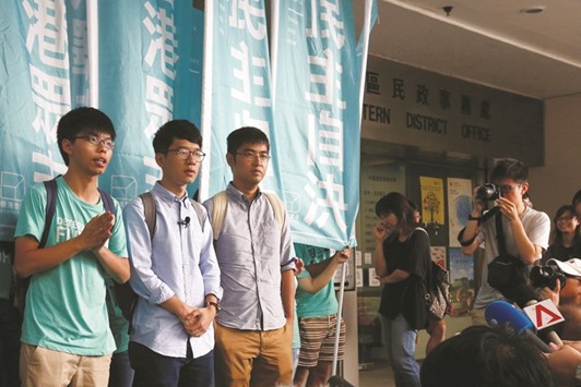 Student leaders (from left) Joshua Wong, Nathan Law and Alex Chow meet reporters before the verdict outside the court building in Hong Kong.