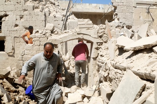 Residents inspect their damaged homes after an air strike on the rebel-held Old Aleppo, Syria yesterday.