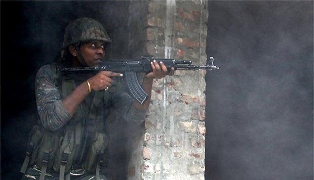 An Indian army soldier takes position inside a building after a gunfight in Srinagar on Monday.