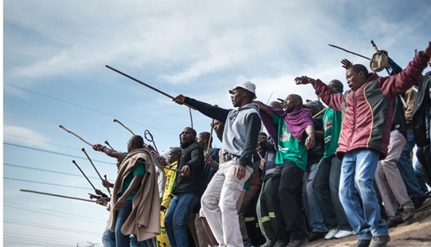 Miners dance during commemorations to mark the fourth anniversary of the Marikana Massacre in Rustenburg on August 16, 2016