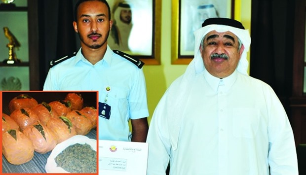 GAC president Ahmed bin Ali al-Mohannadi with the Customs officer responsible for the seizure. Inset: The contraband found in the passenger's bag.