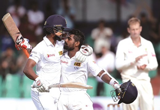 Dinesh Chandimal (left) hugs teammate Kaushal Silva after his century against Australia in Colombo yesterday. (AFP)