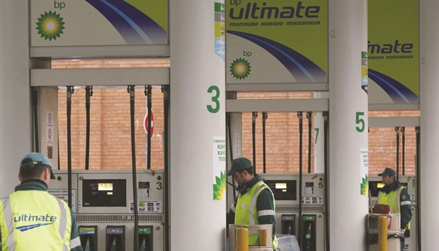 Pump attendants work at a BP petrol station in Moscow. In London trading, BP shares closed up 1% yesterday.