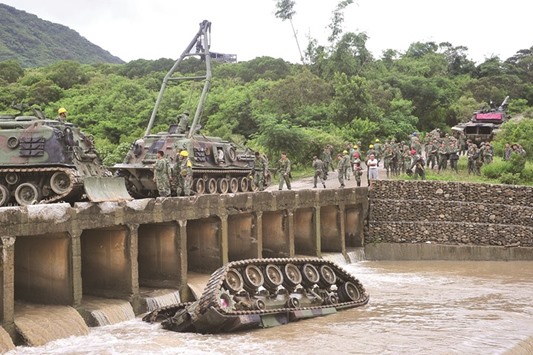 The CM11 armoured vehicle lies upside down in a river, killing three of the five soldiers inside.