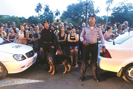 Cuban policemen stand guard near a hotel as fans wait for American pop star Madonna in Havana on Monday.