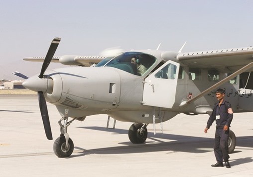 Crew members of a C208 cargo airplane prepare for flight at a military airfield in Kabul.