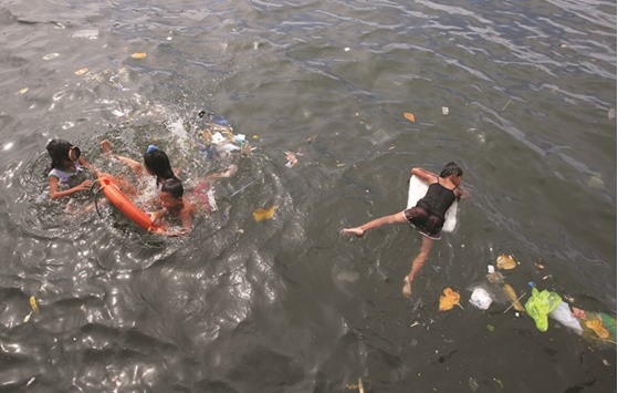 Children swimming in floodwaters of Manila bay, metro Manila.