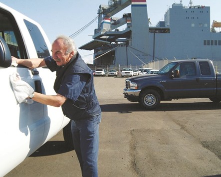 A worker wipes down a Ford F-250 truck outside a Ford dealershipu2019s warehouse at the Port of San Francisco. Ford Motor Co, aiming to put fully autonomous vehicles into the economy by 2021, has announced that itu2019s doubling the size of its office in Silicon Valley to 260 people and investing in four companies that are key to building self-driving cars.