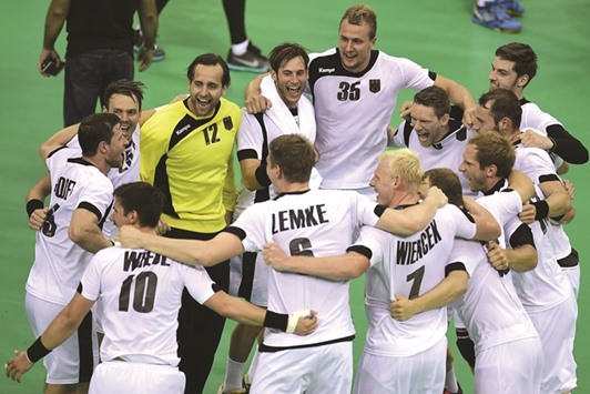 German players celebrate their 34-22 win over Qatar in the quarter-final of menu2019s handball competition yesterday. The reigning European champions will meet defending world and Olympic champions France in the semi-final tomorrow. (AFP)