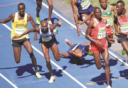 Mo Farah (second from left) tries to balance himself after clipping a falling Mead Hassan (on the ground) in the menu2019s 5000m Round 1 yesterday. (Reuters)