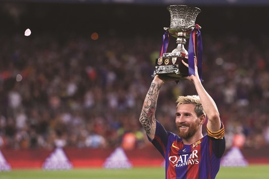 Lionel Messi holds the Spanish Supercup trophy after Barcelonau2019s win over Sevilla at the Camp Nou stadium in Barcelona on Wednesday night.