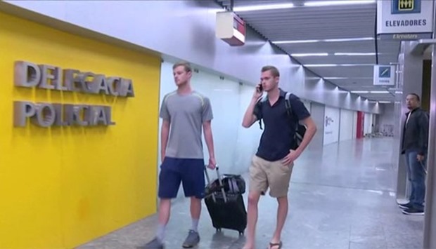 US Olympic swimmers Gunnar Bentz and Jack Conger walk to the airport police station at Rio's international airport in this still frame taken from video.