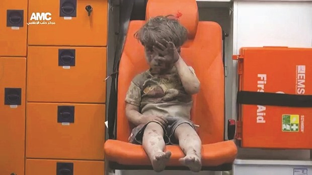 Four-year-old Syrian boy Omran covered in dust and blood in an ambulance after being rescued from the rubble of a building hit by an air strike in the rebel-held Qaterji neighbourhood of Aleppo.