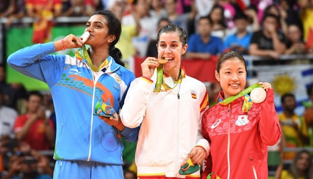 Gold medalist Spain's Carolina Marin (C), Silver medalist India's Pusarla V. Sindhu (L) and Bronze medalist Japan's Nozomi Okuhara stand with their medals on the podium following the women's singles Gold Medal badminton match at the Riocentro stadium in Rio de Janeiro on August 19, 2016, for the Rio 2016 Olympic Games.  AFP