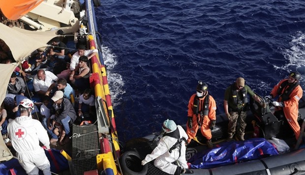A handout picture taken and released on August 19, 2016 by the Italian Red Cross shows crew members of the flagship rescue vessel Phoenix, a rescue boat run by the Malta-based NGO Migrant Offshore Aid Station (MOAS) and the Italian Red Cross (CRI), recovering the bodies of two women, one man and a baby in the Mediterranean Sea yesterday.  AFP