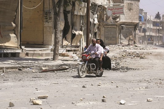 A man driving his motorcycle on a street in the northern Syrian town of Manbij as civilians go back to their homes on August 14  more than a week after  the Syrian Democratic Forces (SDF) pushed the Islamic State (IS) group out of the city. The last remaining IS fighters abandoned the city of Manbij near the Turkish border on August 12.