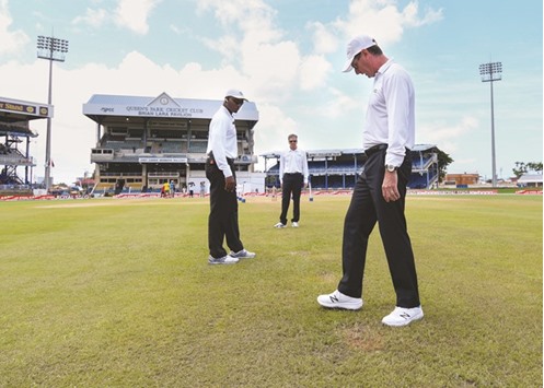 Umpire Rod Tucker (R) Nigel Llong (C) and Gregory Brathwaite (L) inspect the pitch and outfield at Queenu2019s Park Oval in Port of Spain yesterday.