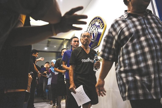 Detainees accused of breaching the Thai juntau2019s ban on political gatherings and for being a member of an unlawful secret society are escorted through a building at the Crime Suppression Division in Bangkok.