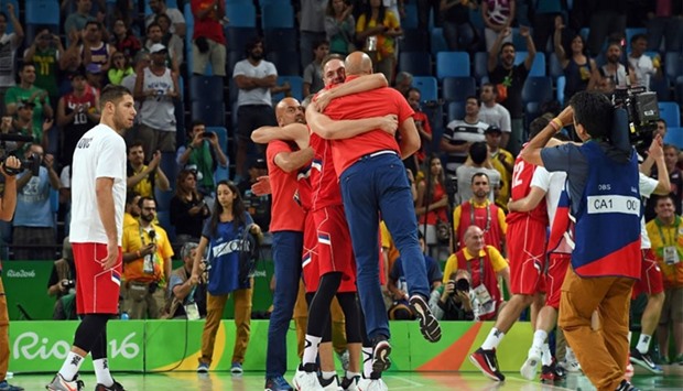 Serbia's centre Vladimir Stimac (C) embraces Serbia's head coach Aleksandar Djordjevic after Serbia defeated Australia during a Men's semifinal basketball match between Australia and Serbia at the Carioca Arena 1 in Rio de Janeiro on August 19, 2016 during the Rio 2016 Olympic Games. AFP
