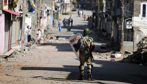 A member of the security forces patrols a street in Srinagar on Sunday after a night of clashes between protesters and security forces as the city remains under curfew.