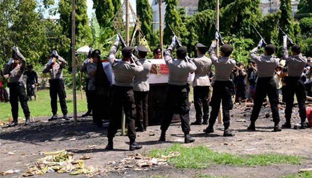 Indonesian policemen prepare to fire their guns on Sunday during a cremation ceremony for police officer Wayan Sudarsa who was killed several days ago in Jimbaran on Indonesia's resort island of Bali.