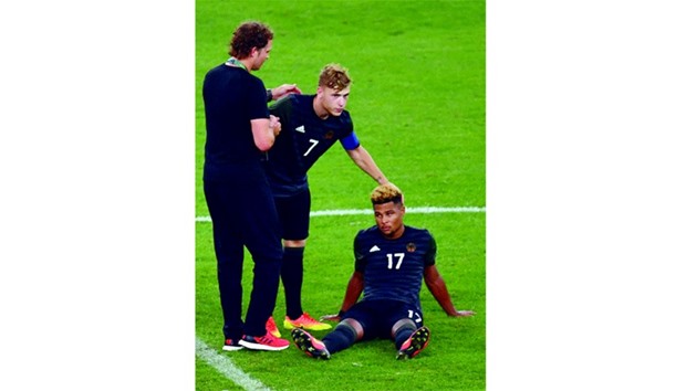 Germanyu2019s Serge Gnabry (R) and teammate Maximilian Meyer react after the penalty shoot-out.