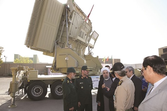 A handout picture provided by the office of Iranian President Hassan Rouhani yesterday shows him and Iranian Defence Minister Hossein Dehghan (second left) standing next to the new Bavar 373 missile defence system in Tehran.
