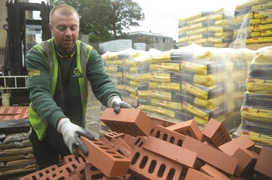 A worker stacks bricks at the depot of a building material supplier in London. UK Construction Purchasing Managersu2019 Index (PMI) inched down to 45.9 in July from 46.0 in June, the lowest reading since June 2009 and some way below the 50 mark that divides growth from contraction.