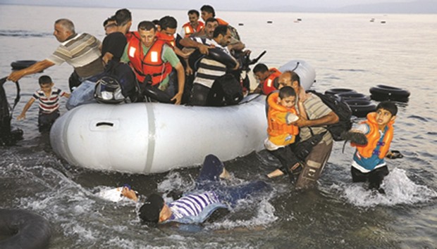 Syrian refugees jumping off an overcrowded dinghy.