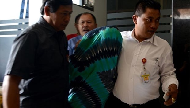 Australian Sara Connor is escorted by Indonesian police during investigation at a police station in Denpasar on Monday.