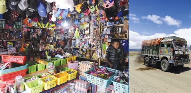 A recent photo shows a Nepalese shopkeeper (centre) and a young boy surrounded by goods in a shop in Lo Manthang in Upper Mustang. Right: A small truck driving along a dirt road in Korala, Nepal-China border in Upper Mustang.