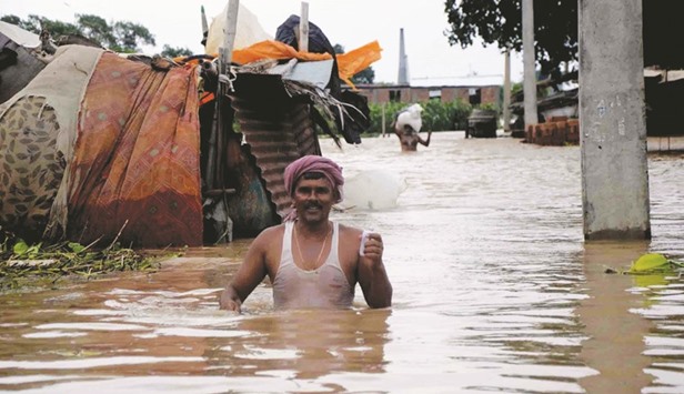 A villager wades through flood waters in his village in Patna district.