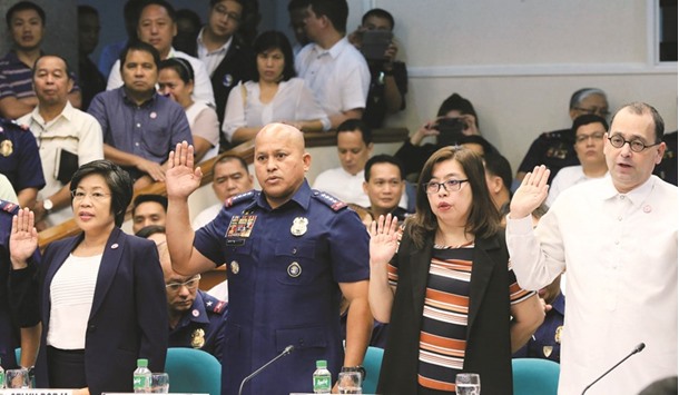 Philippine National Police (PNP) Director General Ronald Dela Rosa takes the oath during the start of a hearing investigating drug-related killings at the Senate headquarters in Pasay city, metro Manila, yesterday. Also pictured are (L-R) Roselyn Borja, officer-in-charge of the Philippine Drugs Enforcement Agency (PDEA), Gwendolyn Pimentel-Gana, member of of the Commission on Human Rights, and Jose Luis Martin Gascon, chairperson of the Commission on Human Rights.
