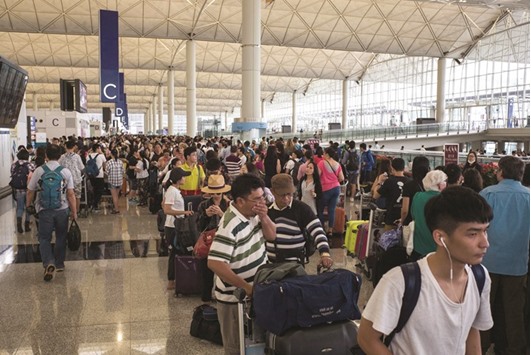 Passengers queuing up as they wait to find out the status of their flights after Typhoon Nida caused chaos at the international airport in Hong Kong yesterday.