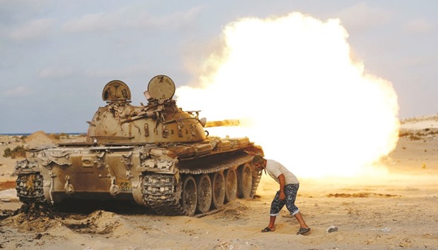 A fighter of Libyan forces allied with the UN-backed government fires a shell with Soviet made T-55 tank at Islamic State fighters in Sirte yesterday.
