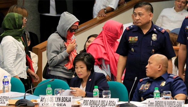 Philippine National Police (PNP) Director General Ronald Dela Rosa looks at relatives of slain people during a Senate hearing investigating drug-related killings