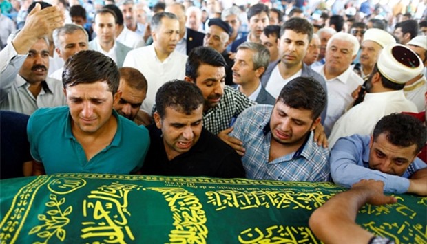 Relatives of one of the victims of Saturday's suicide bombing at a wedding, mourn during the funeral ceremony