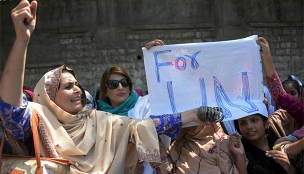 A Pakistani Kashmiri woman shouts slogan as she holds bangles during a protest in Muzaffarabad on Tuesday.